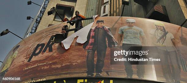 Poster of Aamir Khan-starrer film PK torn by activists of rightwing organizations Bajrang Dal and Hindu Sena outside Delite Cinema Theater on...