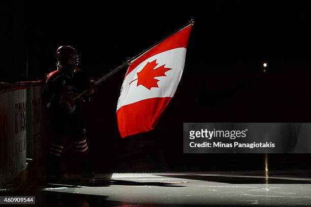 Young flag bearer waves the Canadian flag during the pre game ceremony prior to the 2015 IIHF World Junior Hockey Championship game between Team...