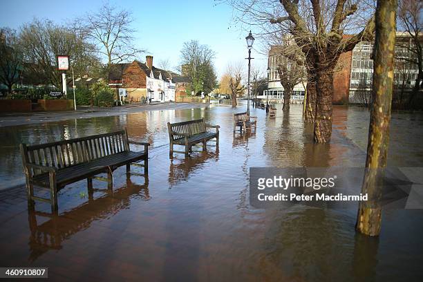 Benches sit in flood water from the River Wey on January 6, 2014 in Guildford, England. Environment Agency flood warnings are in place for parts of...