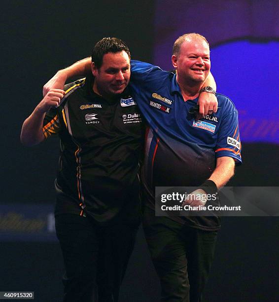 Adrian Lewis of England is congratulated by Raymond van Barneveld of Holland after hitting a nine darter during their third round match during the...