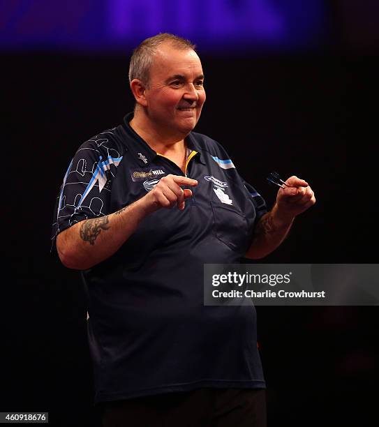 Phil Taylor of England celebrates winning a set during his third round match against Kim Huybrechts of Belgium during the William Hill PDC World...