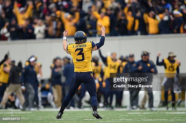 Skyler Howard of the West Virginia Mountaineers celebrates a touchdown against the Texas A&M Aggies during the second quarter of the 56th annual...