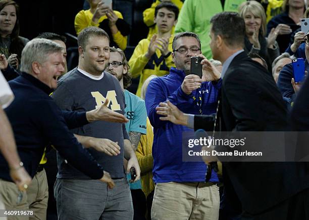 Fans greet Jim Harbaugh, Michigan's new football coach, after he addressed the fans at Crisler Arena during halftime of the Michigan Wolverines game...