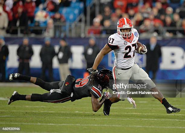 Nick Chubb of the Georgia Bulldogs breaks away from Terell Floyd of the Louisville Cardinals during the Belk Bowl at Bank of America Stadium on...