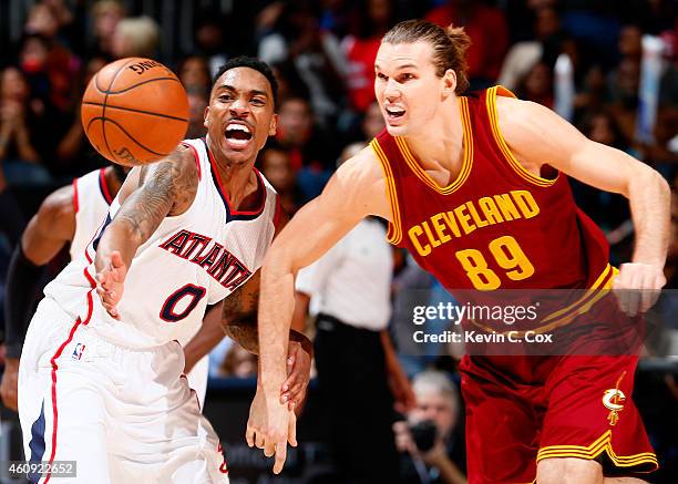 Jeff Teague of the Atlanta Hawks knocks the ball away from Lou Amundson of the Cleveland Cavaliers at Philips Arena on December 30, 2014 in Atlanta,...