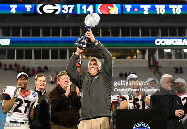 Head coach Mark Richt and the Georgia Bulldogs holds up the trophy after winning the Belk Bowl against the Louisville Cardinals at Bank of America...