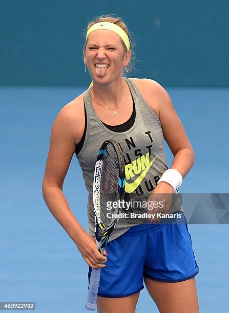 Victoria Azarenka of Belarus pokes her tongue out in jest during a practice session ahead of the 2015 Brisbane International at Queensland Tennis...