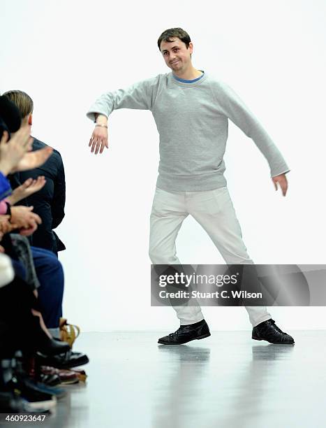 Fashion designer Matthew Miller acknowledges the applause of the audience after his show during The London Collections: Men Autumn/Winter 2014 on...