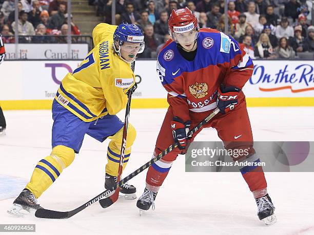 Julius Bergman of Team Sweden keeps a check on Vladimir Bryukvin of Team Russia in a 2015 IIHF World Junior Hockey Championship game at the Air...