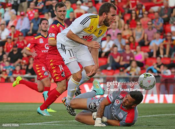 Kenny Cunningham of the Phoenix jumps over goalkeeper Paul Izzo of United as he makes a save during the round 14 A-League match between Adelaide...