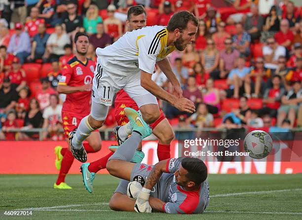 Kenny Cunningham of the Phoenix jumps over goalkeeper Paul Izzo of United as he makes a save during the round 14 A-League match between Adelaide...