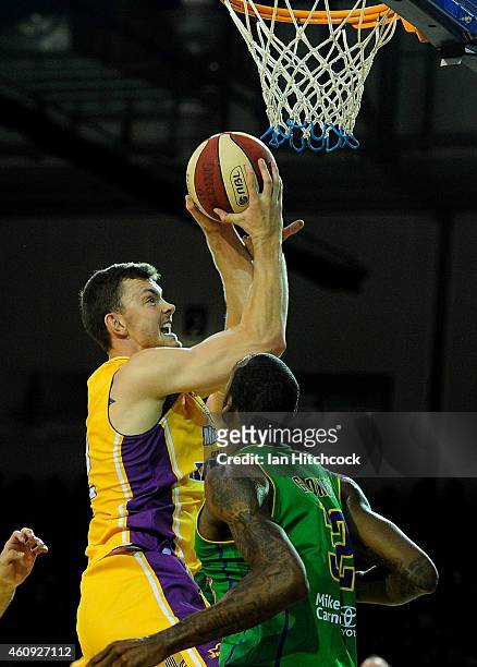Angus Brandt of the Kings attempts a layup past Mickell Gladness of the Crocs during the round 13 NBL match between the Townsville Crocodiles and...