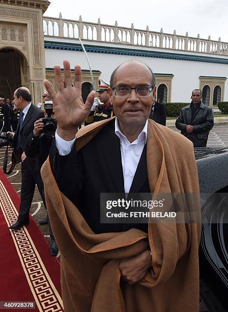 Tunisian former president Moncef Marzouki waves as he leaves the Carthage presidential Palace at the end of a handover ceremony on December 31, 2014...