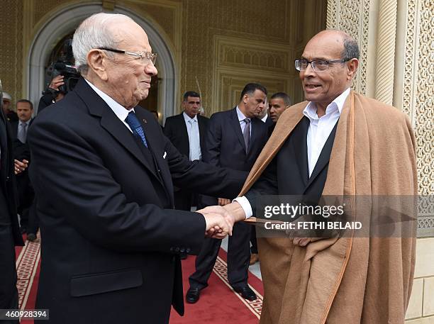 Tunisian newly-elected President Beji Caid Essebsi shakes hands with his predecessor Moncef Marzouki during a handover ceremony on December 31, 2014...