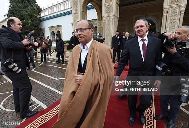 Tunisian newly-elected President Beji Caid Essebsi looks at his predecessor Moncef Marzouki leaving at the end of a handover ceremony on December 31,...