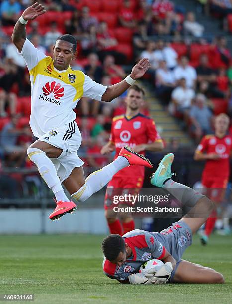 Kenny Cunningham of the Phoenix jumps over goalkeeper Paul Izzo of United as he makes a save during the round 14 A-League match between Adelaide...