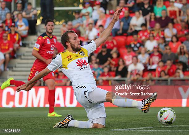 Kenny Cunningham of the Phoenix jumps over goalkeeper Paul Izzo of United as he makes a save during the round 14 A-League match between Adelaide...