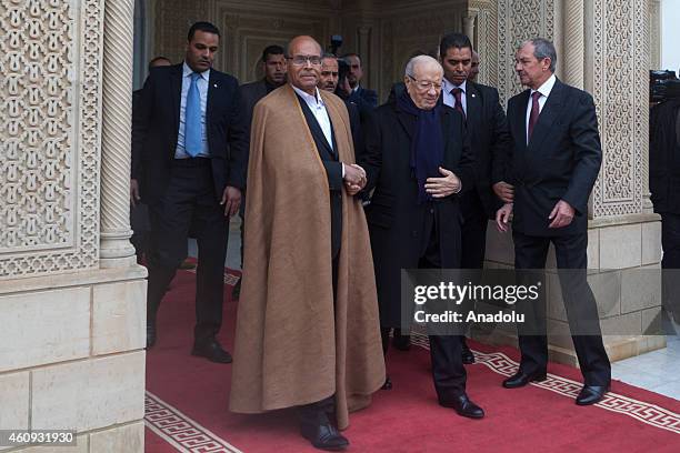 Tunisian newly elected President Beji Caid Essebsi shakes hands with his predecessor Moncef Marzouki during a handover ceremony at the Carthage...