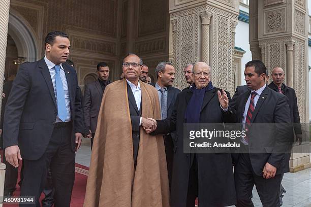 Tunisian newly elected President Beji Caid Essebsi shakes hands with his predecessor Moncef Marzouki during a handover ceremony at the Carthage...