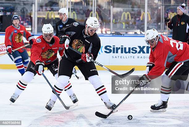 Jonathan Toews, Tim Erixon and Brandon Saad of the Chicago Blackhawks vie for the puck during practice day prior to the 2015 Bridgestone NHL Winter...