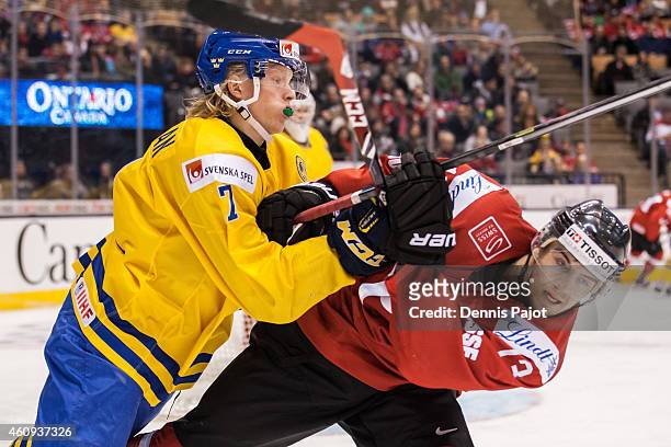 Forward Julius Bergman of Sweden battles against forward Luca Hischier of Switzerland during the 2015 IIHF World Junior Championship on December 31,...