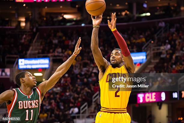 Kyrie Irving of the Cleveland Cavaliers shoots over Brandon Knight of the Milwaukee Bucks during the first half at Quicken Loans Arena on December...