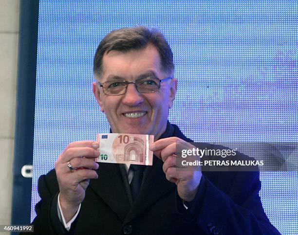 Lithuanian Prime Minister Algirdas Butkevicius withdraws euros from a bank machine on January 1, 2015 during a ceremony in Vilnius. Lithuania...