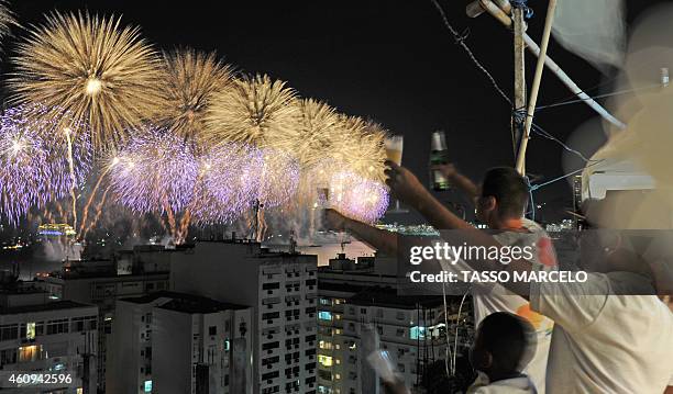 People watch the Copacabana fireworks from the Chapéu Mangueira slum during New Year celebrations in Rio de Janeiro on January 1, 2015. AFP PHOTO /...