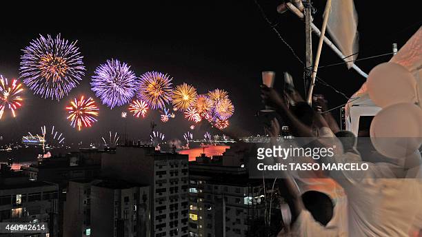 People watch the Copacabana fireworks from the Chapéu Mangueira slum during New Year celebrations in Rio de Janeiro on January 1, 2015. AFP PHOTO /...
