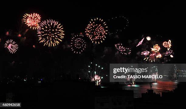 The Copacabana fireworks are seen from the Chapéu Mangueira slum during New Year celebrations in Rio de Janeiro on January 1, 2015. AFP PHOTO / TASSO...