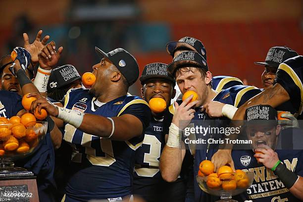 Georgia Tech Yellow Jackets players pose with trophies after winning the Capital One Orange Bowl game against the Mississippi State Bulldogs at Sun...