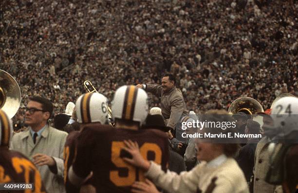 Minnesota coach Murray Warmath victorious being carried off field by players after winning game vs Iowa at Memorial Stadium. Minneapolis, MN...