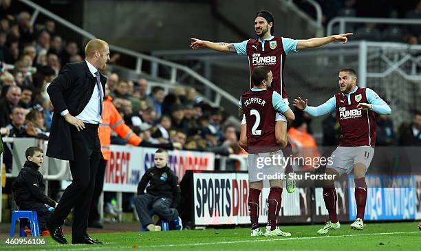 George Boyd of Burnley is lifted up after scoring the third Burnley goal as manager Sean Dyche looks on during the Barclays Premier League match...