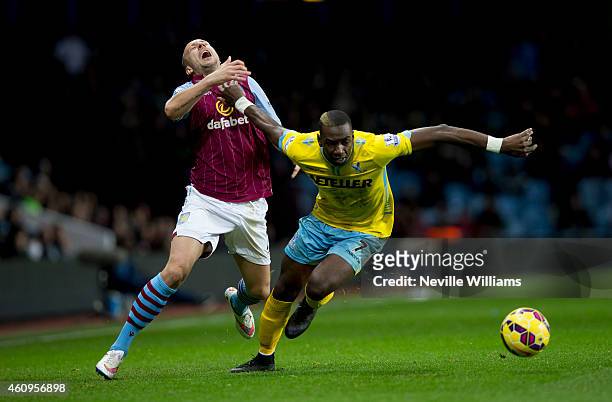 Alan Hutton of Aston Villa is challenged by Yannick Bolasie of Crystal Palace during the Barclays Premier League match between Aston Villa and...