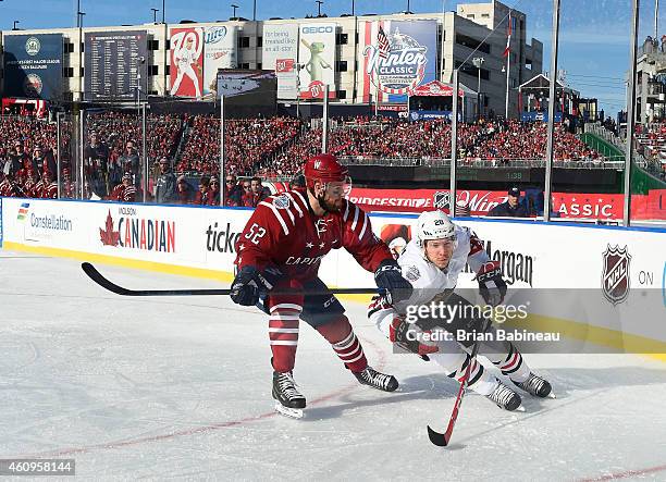 Ben Smith of the Chicago Blackhawks skates around Mike Green of the Washington Capitals in the corner during the first period of the 2015 Bridgestone...