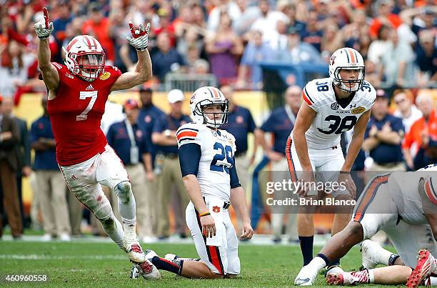 Safety Michael Caputo of the Wisconsin Badgers celebrates as place kicker Daniel Carlson of the Auburn Tigers and punter Tyler Stovall watch as...