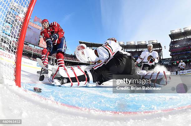 Eric Fehr of the Washington Capitals slides a shot past goaltender Corey Crawford of the Chicago Blackhawks in the first period during the 2015...