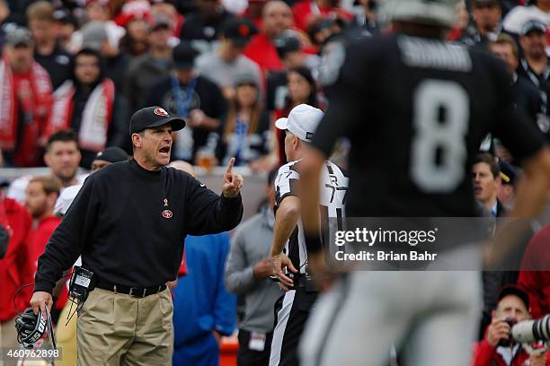 Head coach Jim Harbaugh of the San Francisco 49ers talks with referee Terry McAulay after a touchdown by the Oakland Raiders in the second quarter on...