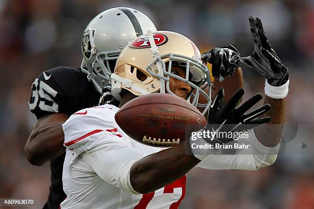 Wide receiver Stevie Johnson of the San Francisco 49ers tries unsuccessfully to pull down a pass against cornerback Chimdi Chekwa of the Oakland...