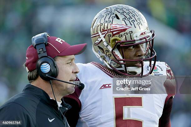 Quarterback Jameis Winston of the Florida State Seminoles speaks with head coach Jimbo Fisher during the College Football Playoff Semifinal against...