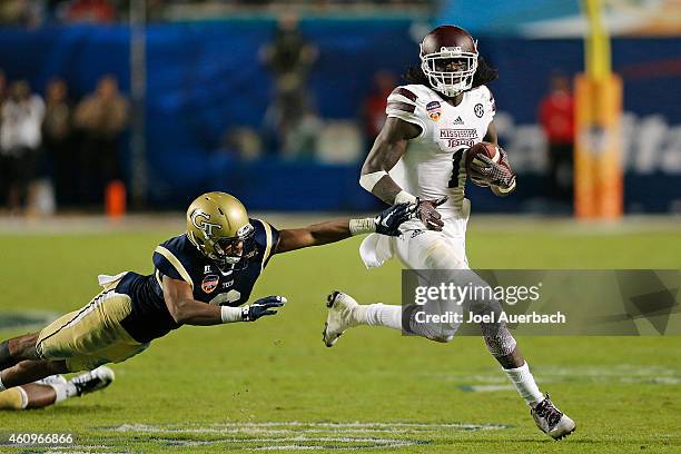 De'Runnya Wilson of the Mississippi State Bulldogs eludes the attempted tackle of Chris Milton of the Georgia Tech Yellow Jackets as he runs with the...