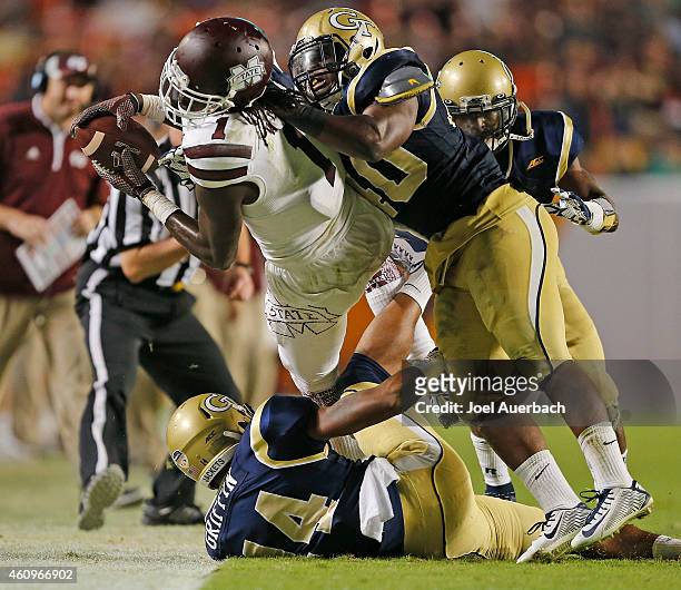 Corey Griffin and P.J. Davis of the Georgia Tech Yellow Jackets tackle De'Runnya Wilson of the Mississippi State Bulldogs during the 2014 Capital One...