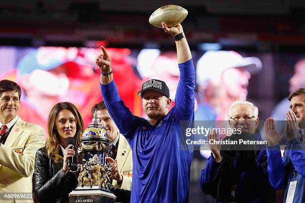 Head coach Bryan Harsin of the Boise State Broncos holds up the Vizio Fiesta Bowl trophy in celebration after defeating the Arizona Wildcats 38-30 at...