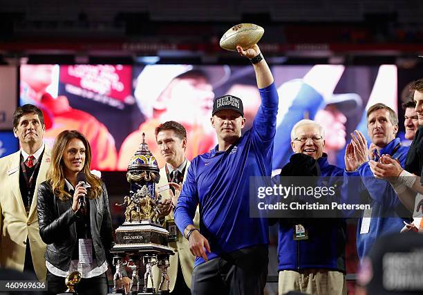 Head coach Bryan Harsin of the Boise State Broncos holds up the Vizio Fiesta Bowl trophy in celebration after defeating the Arizona Wildcats 38-30 at...