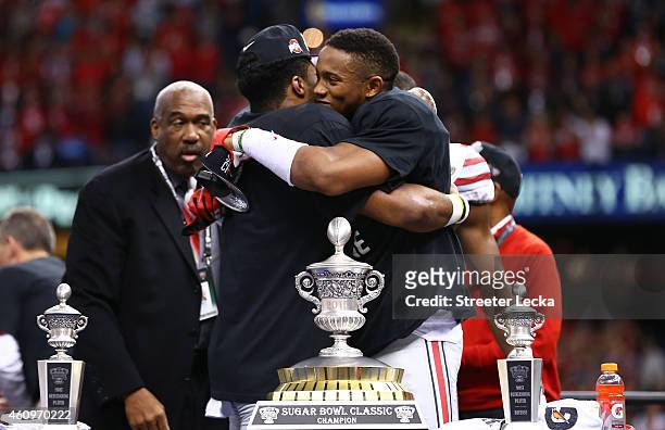Darron Lee and Ezekiel Elliott of the Ohio State Buckeyes celebrate with the trophy after defeating the Alabama Crimson Tide in the All State Sugar...