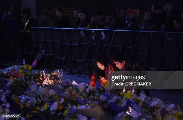 Couple place flowers at the site of the New Year's Eve stampede in Shanghai on January 2, 2015. The New Year's stampede just before midnight on...