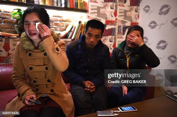 Li Juan , Li Biaojiu and Luo Liuying grieve over the death of their relative Li Na, who died in a stampede on New Year's Eve, in Shanghai on January...