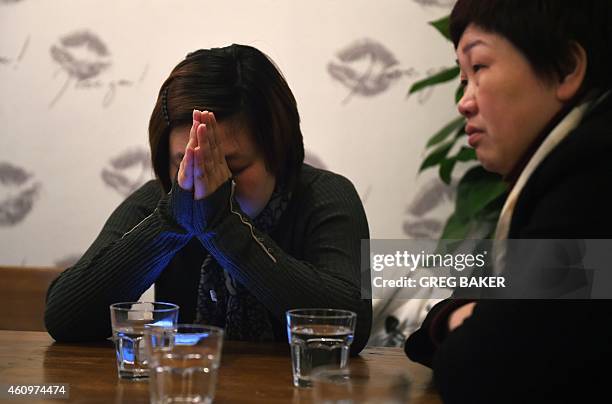 Cai Jinjin and Chen Yan, cousins of stampede victim Qi Xiaoyan, rest in a room near a government compound in Shanghai on January 2, 2015. A New...