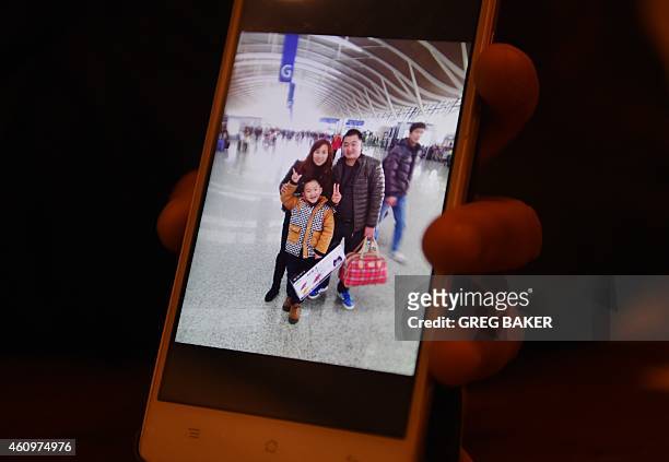 Fan Ping, the wife of Du Shuanghua, who died in a stampede on New Year's Eve, shows a photo of the family in Shanghai on January 2, 2015. The New...