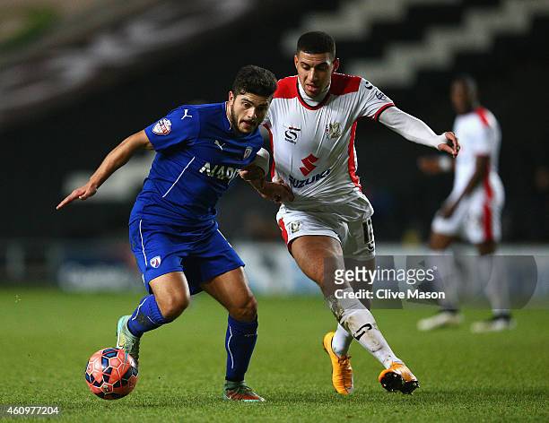 Sam Morsy of Chesterfield is tackled by Daniel Powell of MK Dons during the FA Cup Second Round Replay match between MK Dons and Chesterfield at...